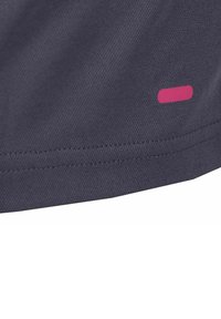 Tejido gris oscuro con una superficie texturizada, que presenta un destacado acento rectangular rosa. Las costuras son visibles a lo largo del borde.
