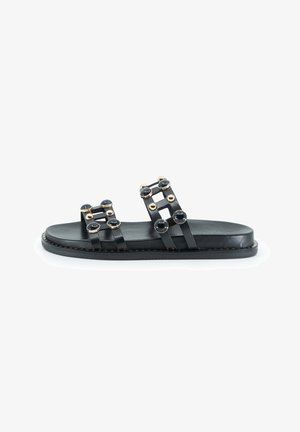 Sandali piatti in pelle nera con due ampie fascette decorate con accenti circolari dorati e neri, suola piatta e cuciture a contrasto.