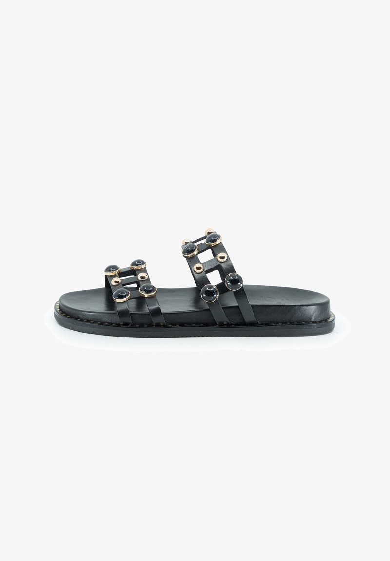 Sandali piatti in pelle nera con due ampie fascette decorate con accenti circolari dorati e neri, suola piatta e cuciture a contrasto.
