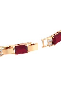 Złota bransoletka z dużymi czerwonymi prostokątnymi kamieniami i małymi przezroczystymi kwadratowymi akcentami, o gładkim metalicznym wykończeniu i zapięciu na klamrę.