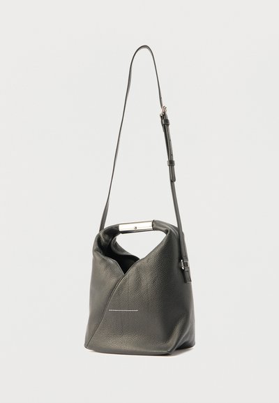 Czarna skórzana torebka na ramię o unikalnym złożonym designie, ze srebrnymi okuciami i długim, regulowanym paskiem. Zawiera subtelny biały detal szycia.