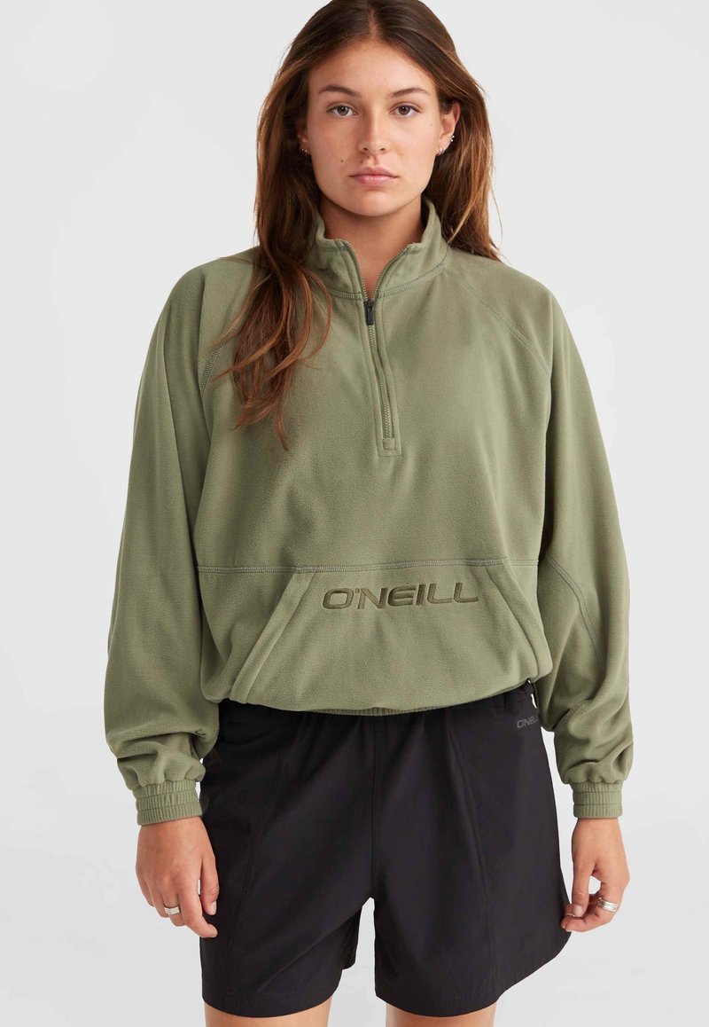 Green fleece pullover with a half-zip, featuring an embroidered logo and elastic cuffs, paired with black shorts. Textured fabric.