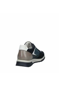 Zapatilla que presenta una mezcla de materiales en cuero y nobuk en tonos azul marino, gris y blanco, con un talón texturizado y una suela de goma.