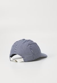 Navy blue and white striped baseball cap made of fabric, featuring a curved visor and an adjustable strap at the back.