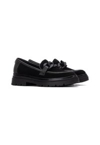 Zapatos negros sin cordones con suela gruesa, que presentan una textura suave, una correa decorativa y acentos de nudos en la parte delantera.