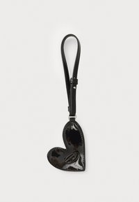 Black patent leather heart-shaped bag with a smooth texture, featuring a strap for hanging. The interior includes a contrasting design detail.