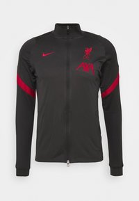 Sort zip-up atletisk jakke med lange ærmer, røde accenter, Liverpool FC-logo og AXA-branding. Lavet af glat, letvægtsmateriale.