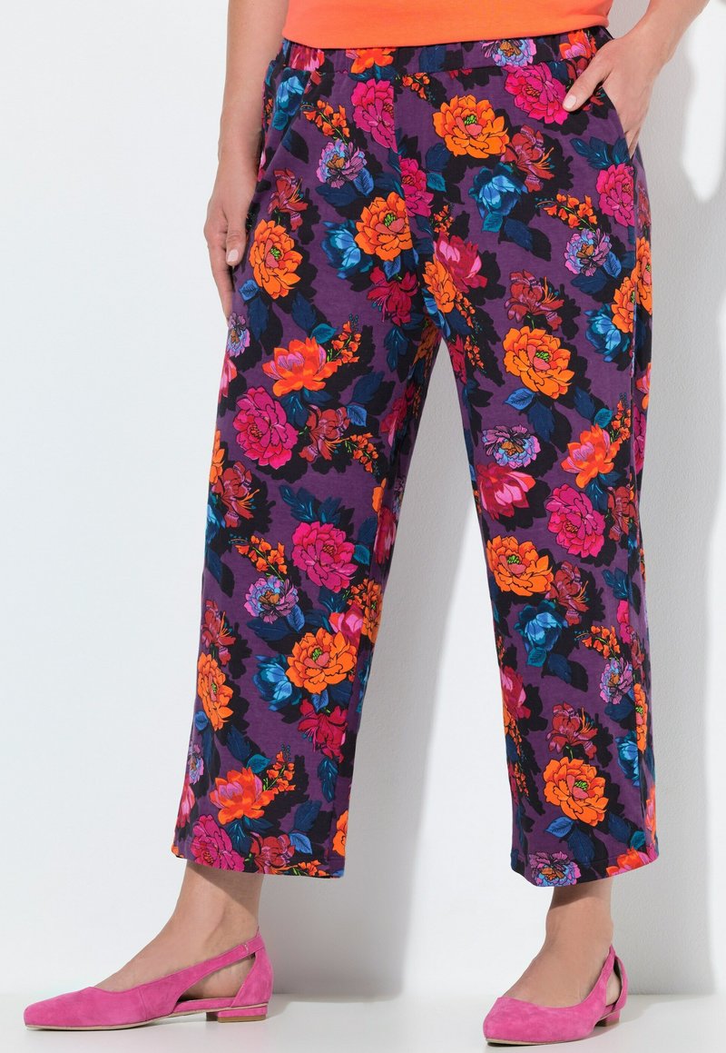 Bloemmotief, paarse stoffen broek met felle oranje, roze en blauwe bloemen. Heeft een elastische tailleband en zijzakken.