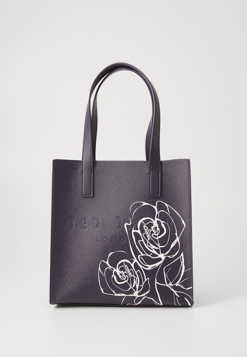 Sac cabas en cuir noir avec double poignée, logo embossé "Ted Baker London" et motifs de roses blancs en contour dans le coin inférieur droit.