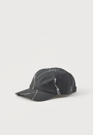 Casquette de baseball noire avec des motifs de stries blanches semblables à du marbre sur un fond clair, vue d’un angle avant latéral.