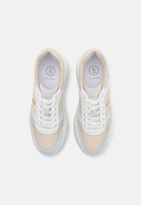 Sneakers i beige og grå med mesh-materiale, hvite snørebånd, logodetalj og polstret krage. Har en tykk hvit såle.