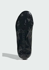 Czarna podeszwa korków piłkarskich z formowanymi kołkami, logo "PREDATOR" oraz znak Adidas na jasnoszarym tle.