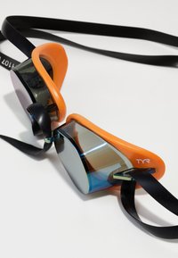 Gafas de natación TYR con un diseño elegante y aerodinámico. Montura de silicona naranja con lentes espejadas y correas negras ajustables.