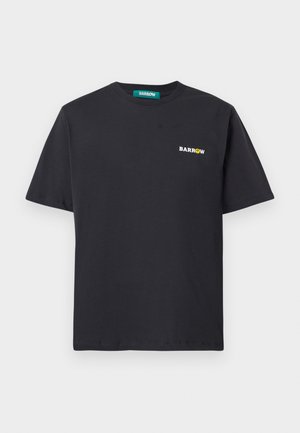 T-shirt di cotone nero con maniche corte e colletto rotondo. Presenta un piccolo logo bianco con testo giallo accentato sul lato sinistro superiore.