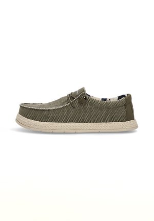 Zapatilla de lona verde oliva con una parte superior texturizada, suela trenzada de color claro en contraste y un detalle de cordones en la parte delantera. El interior cuenta con un forro estampado.