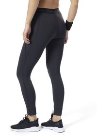Czarne legginsy sportowe z wysokim pasem, o gładkiej fakturze i dopasowanym kroju. Akcentowane subtelnymi detalami przeszyć.
