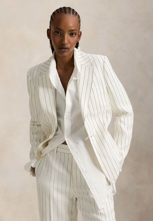 Costume blanc à fines rayures avec un blazer structuré, une chemise à col et un pantalon sur mesure. Présente des lignes nettes et un design moderne et élégant.