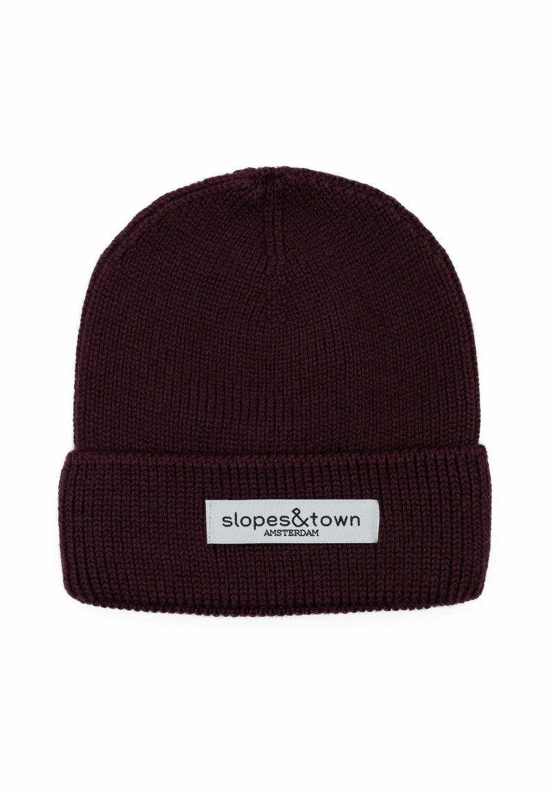Berretto lavorato a maglia di colore bordeaux con orlo arrotolato, dotato di un'etichetta bianca con la scritta "slopes&town AMSTERDAM" in testo nero. Materiale morbido e dalla trama. 