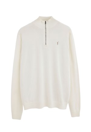 Kremowy sweter z długim rękawem, z prążkowanym, półgolfem i półzamek błyskawiczny, z małą haftowaną postacią na piersi.