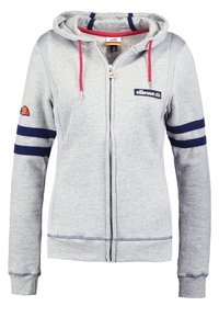 Felpa grigia con zip, cappuccio regolabile con coulisse, righe blu navy sulle maniche, toppa del logo sul petto e polsini e orlo a coste. Realizzata in tessuto morbido.