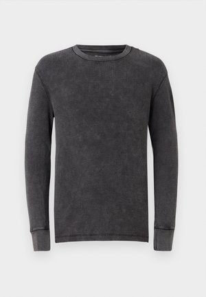 Donkergrijze langmatige crewneck trui van ribbelstof, met een ronde halslijn en manchet mouwen.
