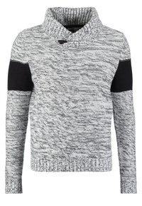 Grå och svart melerad stickad tröja med hög, vikbar krage som har en knappstängning och enfärgade svarta armbågsfläcken på långa ärmar.