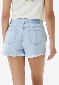 Light blue denim shorts with a frayed hem, featuring a high waist and two back pockets. The fabric appears soft and casual.