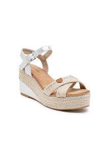 Sandales compensées blanches avec des brides en fibres naturelles tissées, des accents métalliques et une plateforme texturée argentée. Semelle intérieure beige douce. Fermeture à boucle.