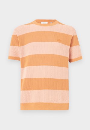 Pull court à manches courtes rayé en orange et rose clair, avec un col rond côtelé et un tissu texturé avec un petit logo brodé.
