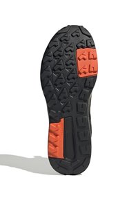 Semelle en caoutchouc noire avec des accents orange contrastants, dotée de crampons de traction multidirectionnels et d'une surface texturée pour une bonne adhérence.