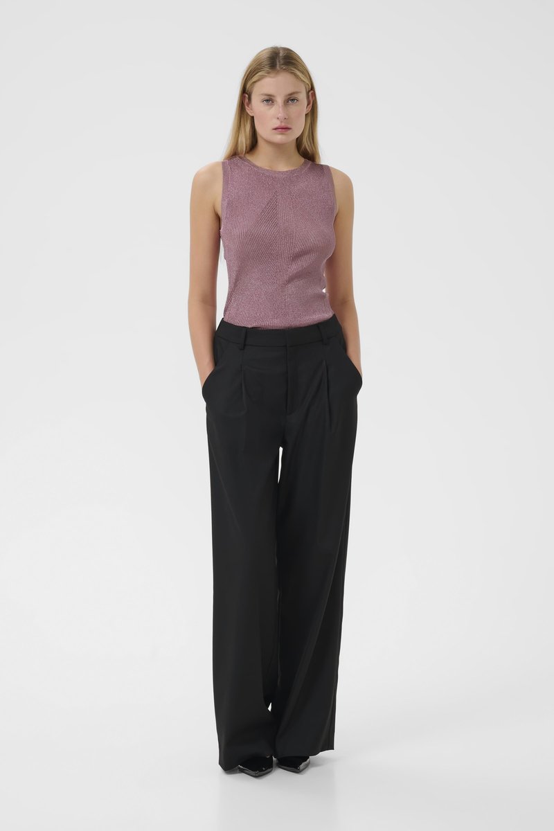 Pink knitted sleeveless top paired with high-waisted black wide-leg trousers. Trousers have front pleats; top features a textured design.