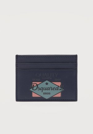 Porte-cartes bleu marine avec trois fentes, arborant un logo multicolore "Dsquared2 Bros" et le texte "Qualité conçue par Dean et Dan."