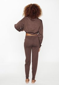 Ensemble de salon marron et texturé composé d'un haut court à manches longues et d'un pantalon fuselé assorti, tous deux en tissu doux.