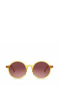 Lunettes de soleil rondes avec des montures translucides jaunes et des verres dégradés roses. Présente des accents orange sur les branches. Texture lisse, design moderne.