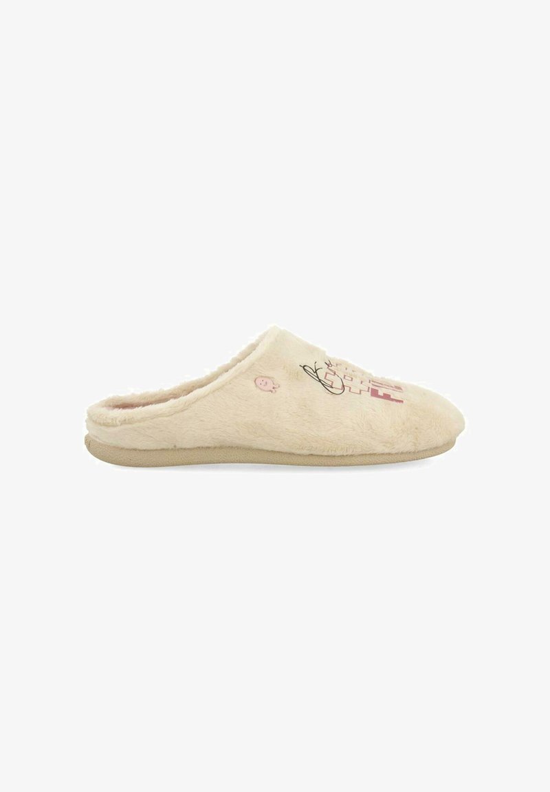 Chausson en beige, duveteux, à enfiler, avec une texture douce, présentant un motif décoratif et une semelle plate. Bout arrondi et intérieur rembourré pour un grand confort.