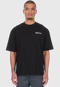 Black cotton t-shirt with a relaxed fit, short sleeves, and a white "DROPSIZE" logo printed on the left chest area.