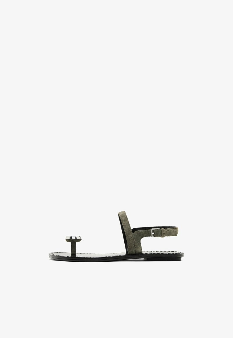 Olijfgroene suede sandalen met open teen, voorzien van een dunne enkelband met een gesp, een ronde teengreep en een platte zwarte zool.