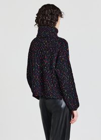 Maglione spesso nero lavorato a maglia con colletto alto, caratterizzato da macchie colorate, lunghezza cropped e vestibilità morbida. Design con costine texture.