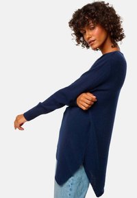 Navyblaues Langarm-Sweatshirt mit lockerer Passform, seitlichen Schlitzen, gerippten Bündchen und einem leicht verlängerten hinteren Saum, aus weichem Stoff gefertigt.