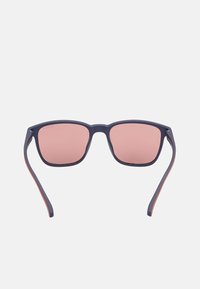 Gafas de sol con montura marina y lentes rectangulares, que cuentan con lentes de tono rosa y acentos naranjas contrastantes en las patillas.