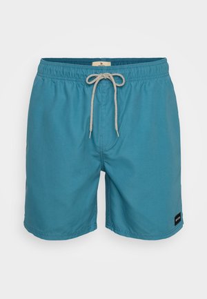 Teal svømmebukser laget av lett stoff, med elastisk midjebånd og snøring, sidelommer og et lite logo-merke.