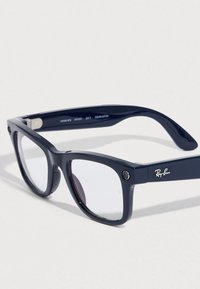 Gafas de sol Ray-Ban azul marino con lentes rectangulares, acabado mate y un detalle redondo de metal en la patilla. Presentan un logo plateado.