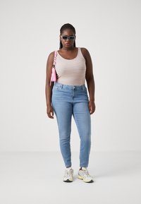 Striped tank top with orange, yellow, and blue colors, paired with light blue skinny jeans. Accented with a pink handbag and sunglasses.