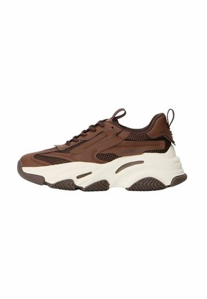 Sneaker marrone con tomaia in rete e pelle, suola intermedia spessa bianca, suola in gomma testurizzata e chiusura con lacci. Presenta un'etichetta sul retro.