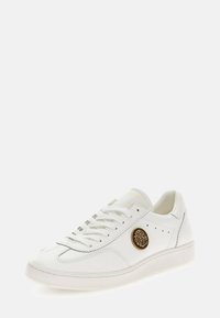 Sneaker in pelle bianca con punta tonda, suola in contrasto color avorio e emblematico leone dorato di lato. Lacci piatti e dettagli perforati.