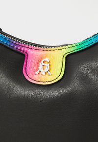 Black leather bag with a colorful gradient fabric trim. Features silver hardware and a logo in a stylized font attached to the trim.