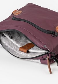 Paarse leren tas met een ritssluiting, voorzien van een textuurvoering, leren accent en meerdere binnenvakken voor organisatie.