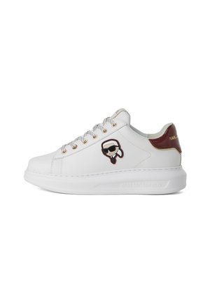 White leather sneaker with a textured design, featuring gold eyelets, a maroon heel accent, and a cartoon logo patch on the side.
