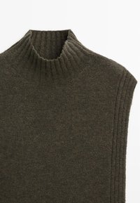 Gilet senza maniche a collo alto in verde oliva scuro. Presenta un colletto a coste e dettagli laterali con un tessuto morbido e testurizzato.
