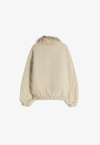 Beige dzseki műszőrme gallérral, rugalmas aljjal és mandzsettával, oversized sziluettel és sima anyag textúrával. Nincsenek látható záródások vagy részletek.